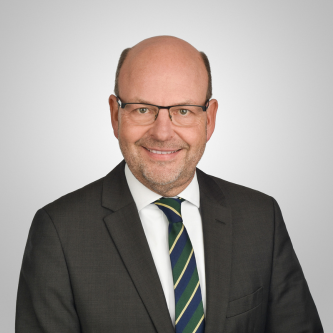 Portrait von Prof. Dr. Heinz Dieter Quack im Anzug vor grauem Hintergrund